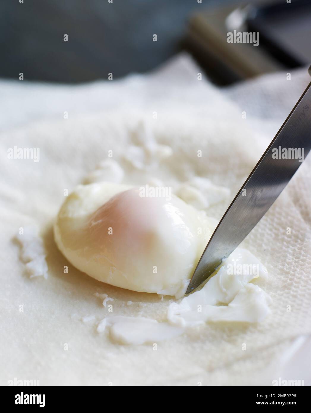 Trimming around edge of poached egg using sharp knife Stock Photo Alamy