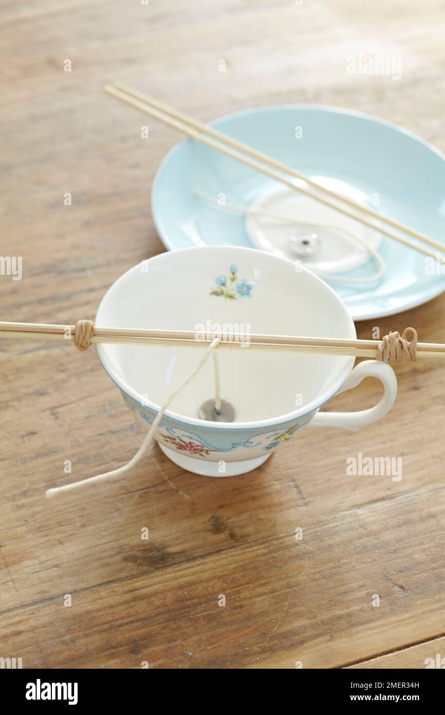 Wick holder keeping wick in place in a small ceramic cup (making cup