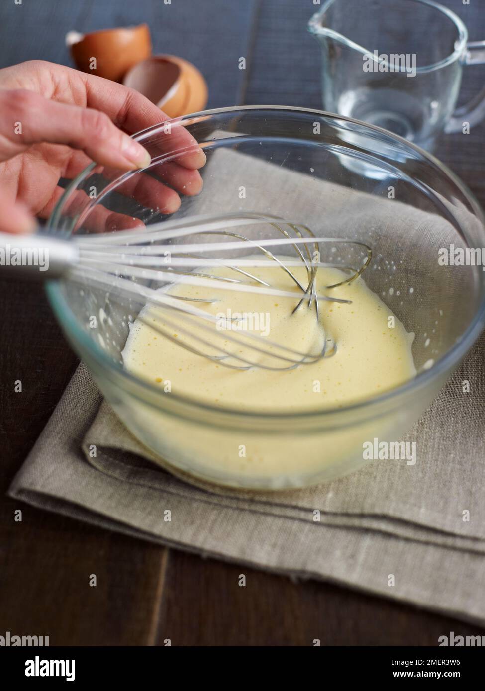 Mixing egg yolks with a little cold water in bowl (cooking hollandaise sauce Stock Photo Alamy