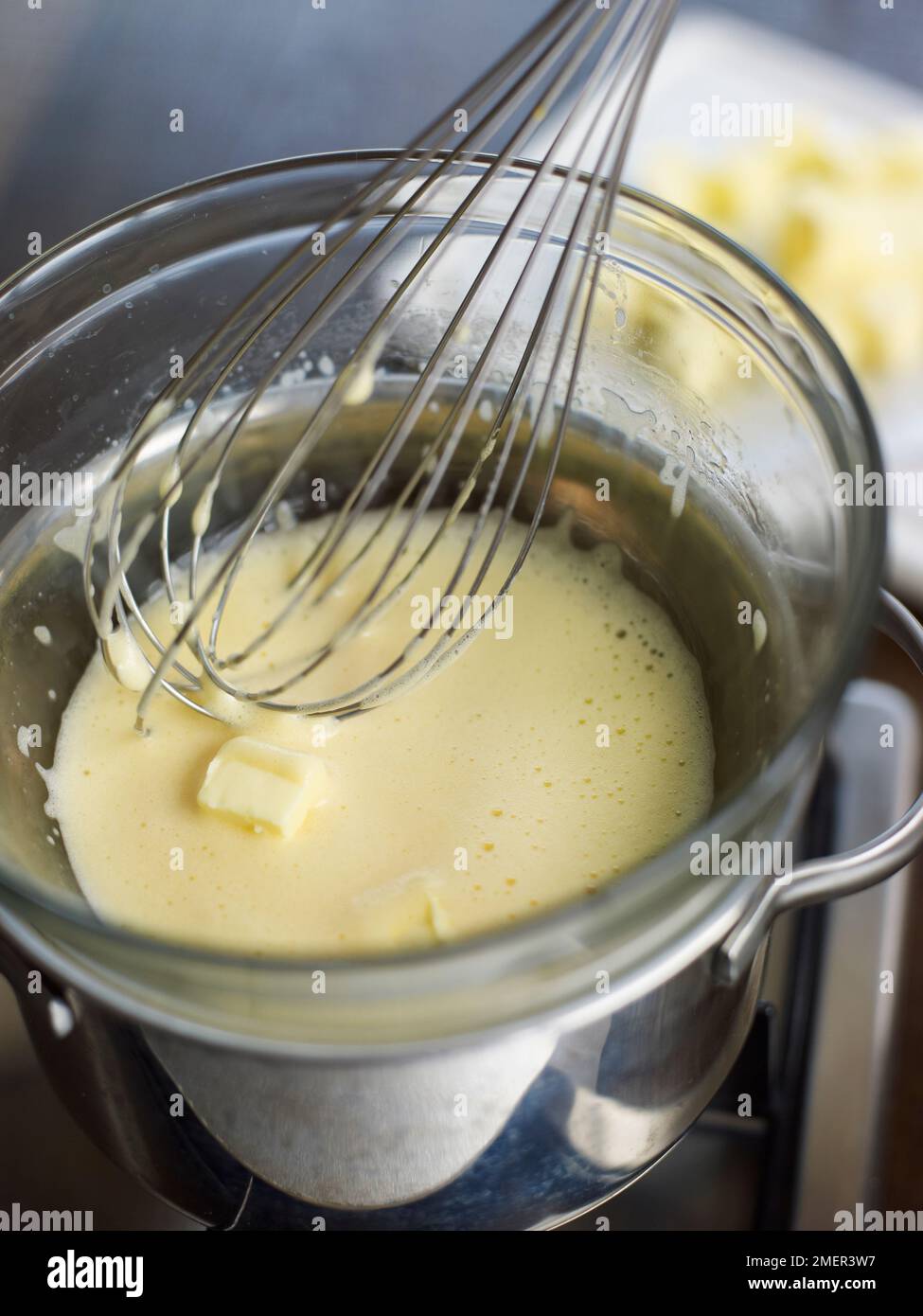 Melting in butter with yolks in heatproof bowl set over saucepan