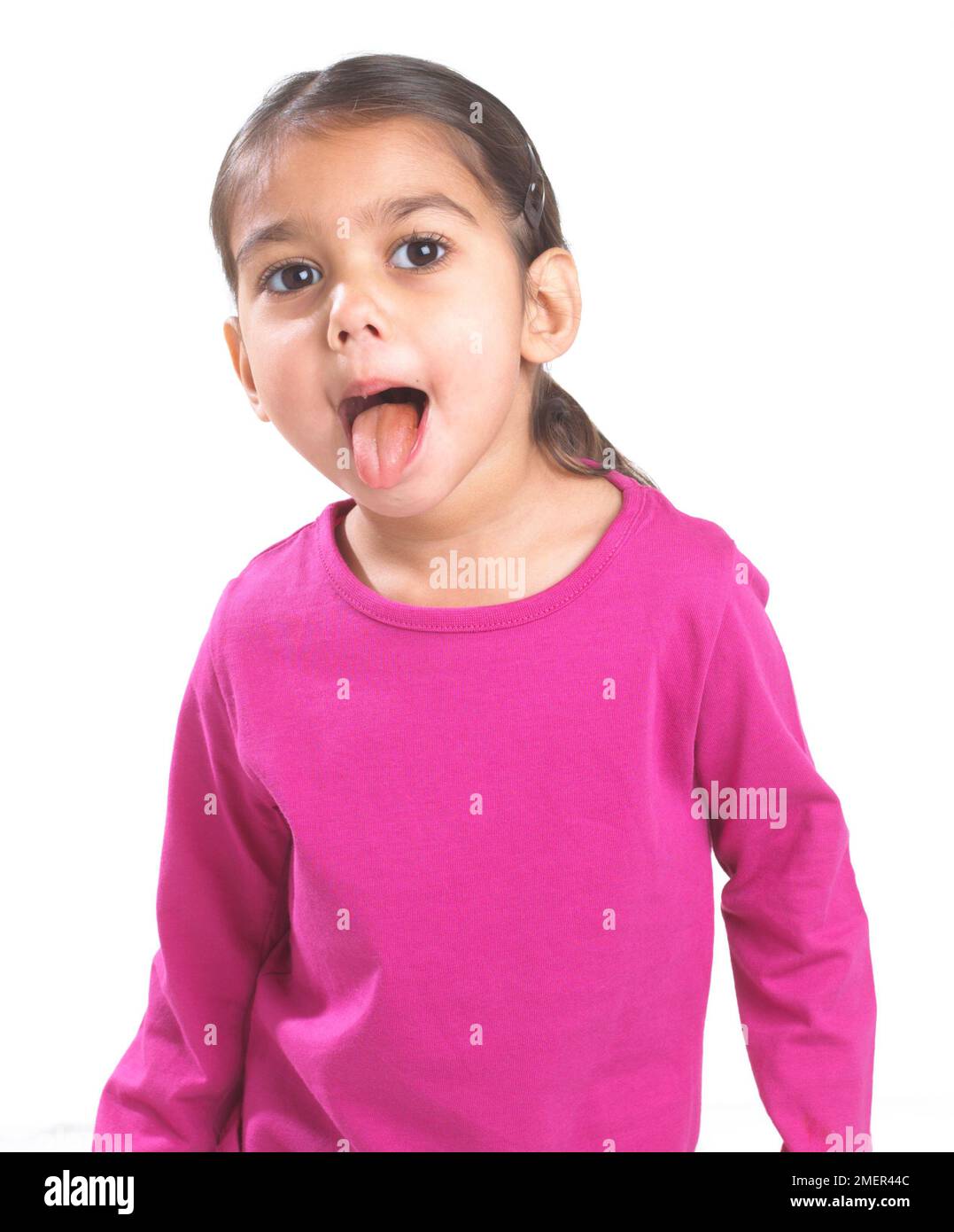 Girl in pink shirt sticking her tongue out, 3.5 years Stock Photo
