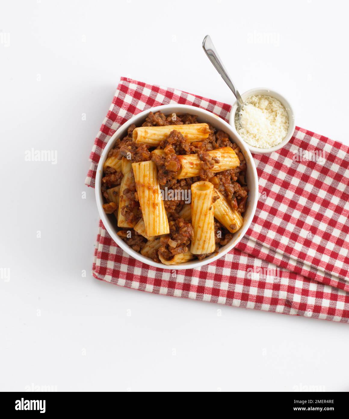 Individual bowl of rigatoni pasta and bolognese sauce and Parmesan ...