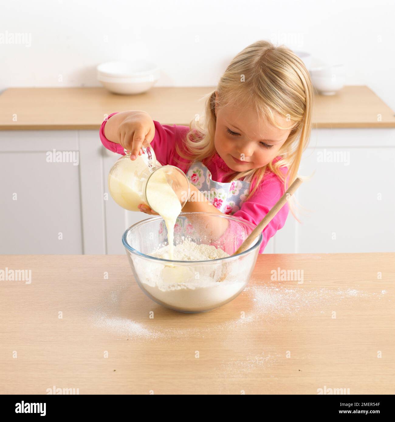 Pouring, yogurt, eggs and melted butter mixture into bowl of flour, 3