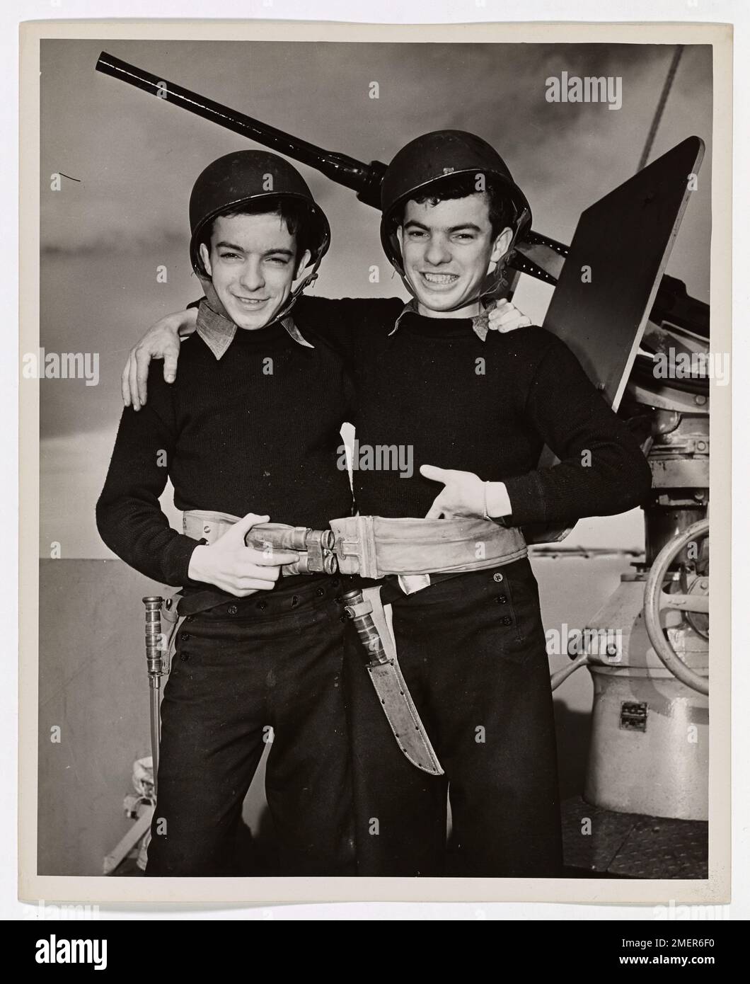 Bostonese Twins On An Atlantic Transport. They are 17-year-olds--These Coast Guard twins from Dorchester, Mass., and they look as near alike as those famous characters, 'Ike and Mike.' In fact, one of the Collins brothers is named Mike, but his brother happens to be John. Mike is the one on the left or perhaps he's the one on the right. What difference does it make? The Collins twins enlisted together in Boston on November 17, 1944, at the age of 17. They now serve on a Coast Guard-manned troop transport ferrying reinforcements across the Atlantic. One lifebelt, it seems, suffices for both. Th Stock Photo