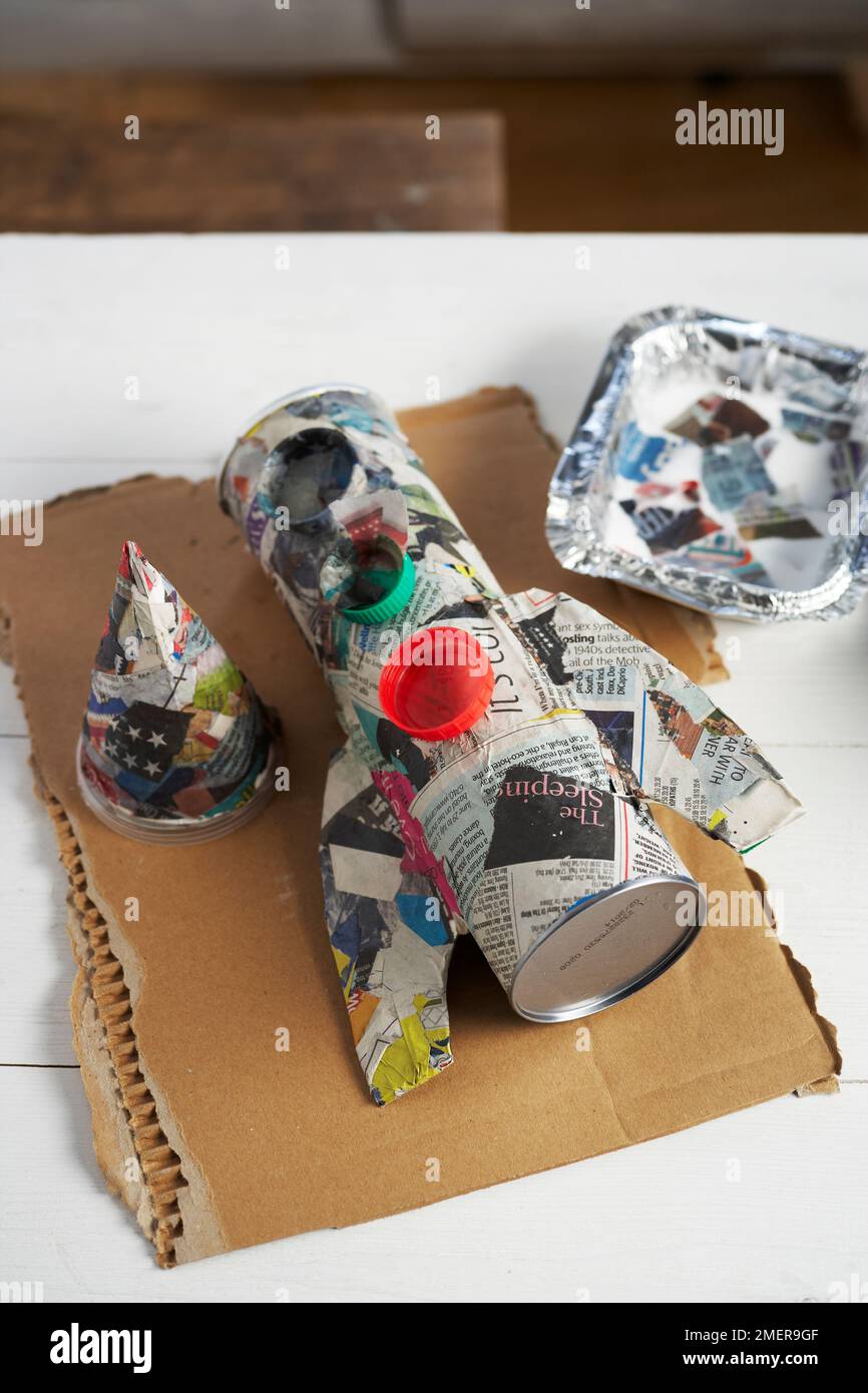 Making rocket pen pot, covering tube with layer of papiermache Stock