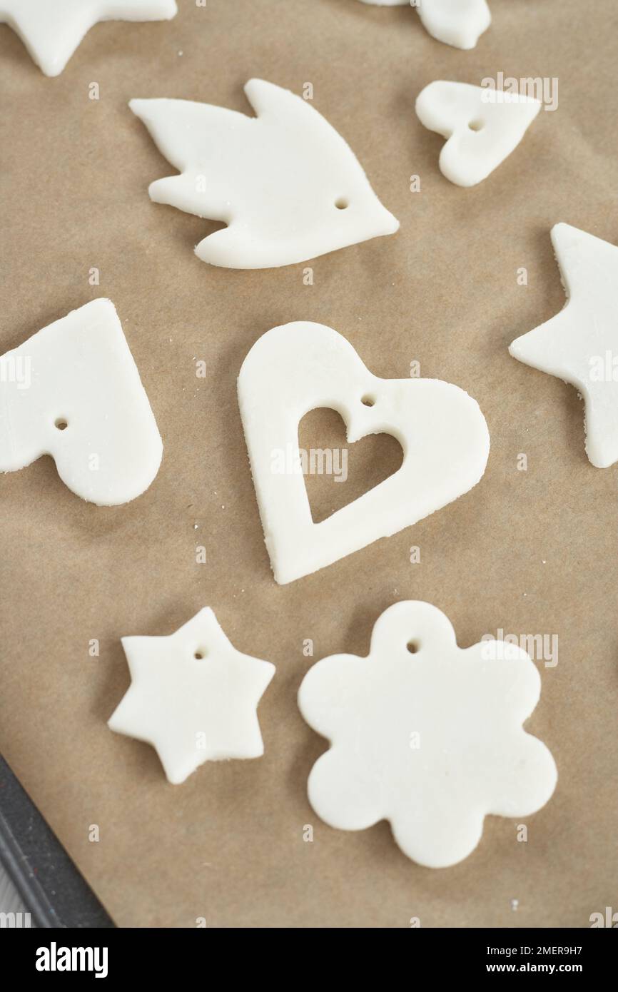 Making pendants made from bicarbonate of soda and corn flour, making hole at top of each shape