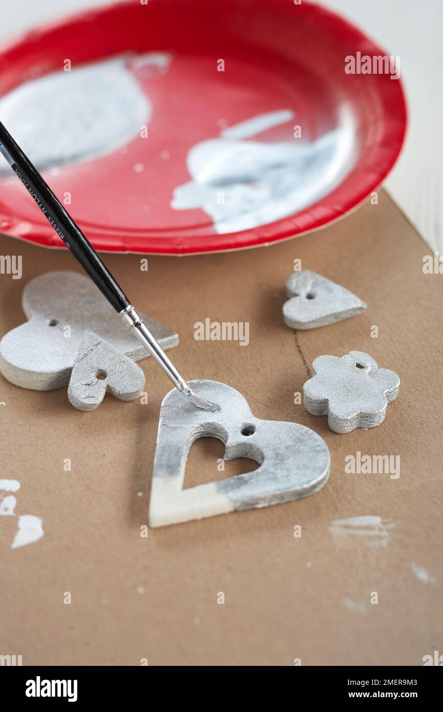 Painting heart shaped pendants silver Stock Photo
