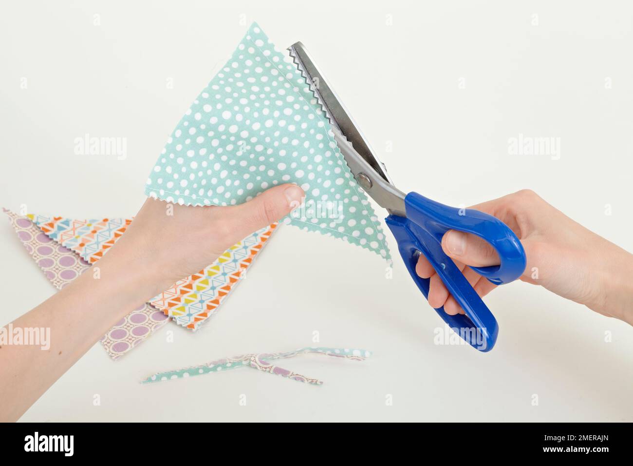 Making bunting, use pinking shears to trim flags Stock Photo Alamy