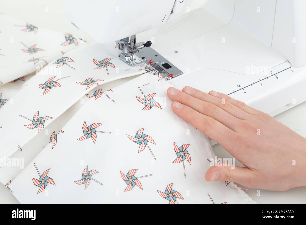 Fold, pin and sew folds in the fabric, making cot hanger or cot