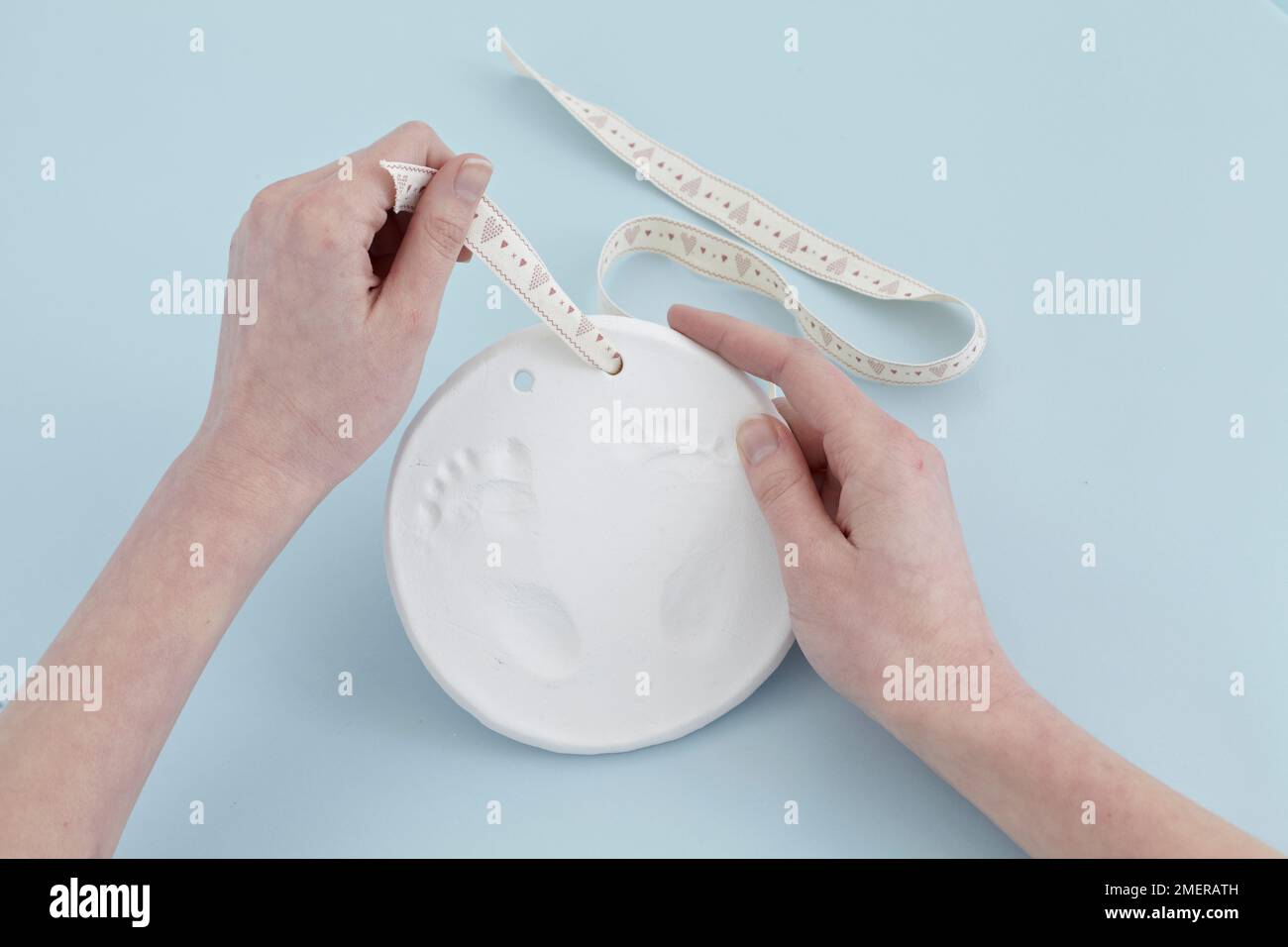 Threading ribbon through holes on top of footprint plaque Stock Photo Alamy