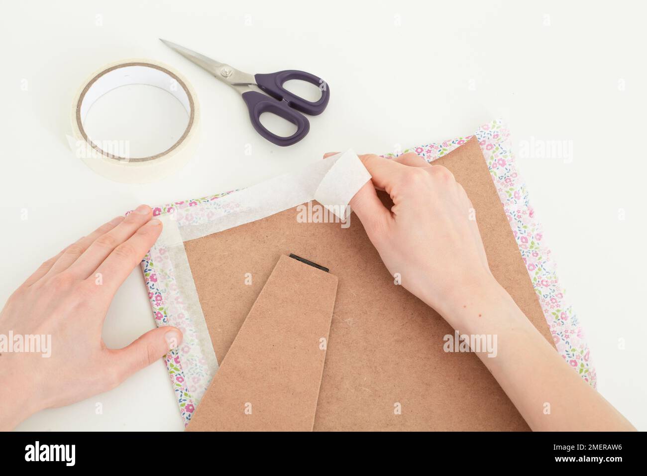 Taping excess fabric on backing board, picture frame Stock Photo Alamy