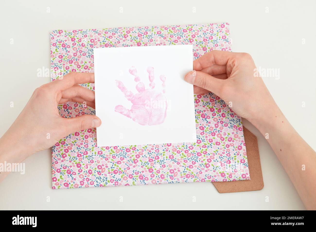 Placing hand print on square pattern fabric Stock Photo