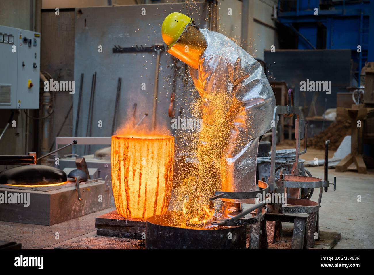 Berlin, Germany. 24th Jan, 2023. An employee scoops molten bronze to cast a Berlinale Bear at the Hermann Noack picture foundry. The trophies of the Berlin International Film Festival are cast, manufactured and finished in the foundry. Credit: Christoph Soeder/dpa/Alamy Live News Stock Photo