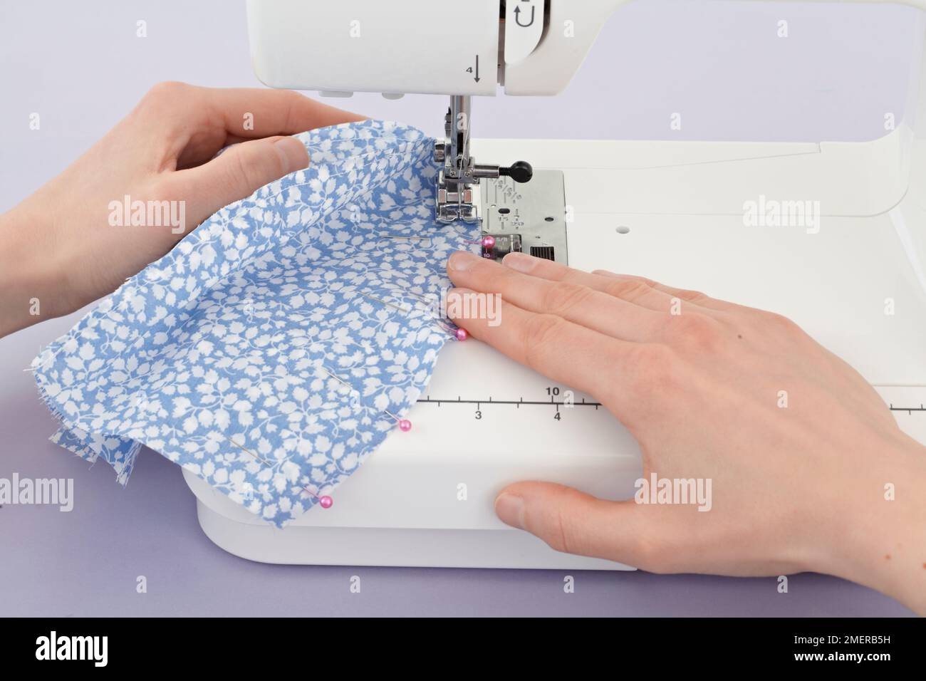 Sewing along pinned edge of fabric Stock Photo Alamy