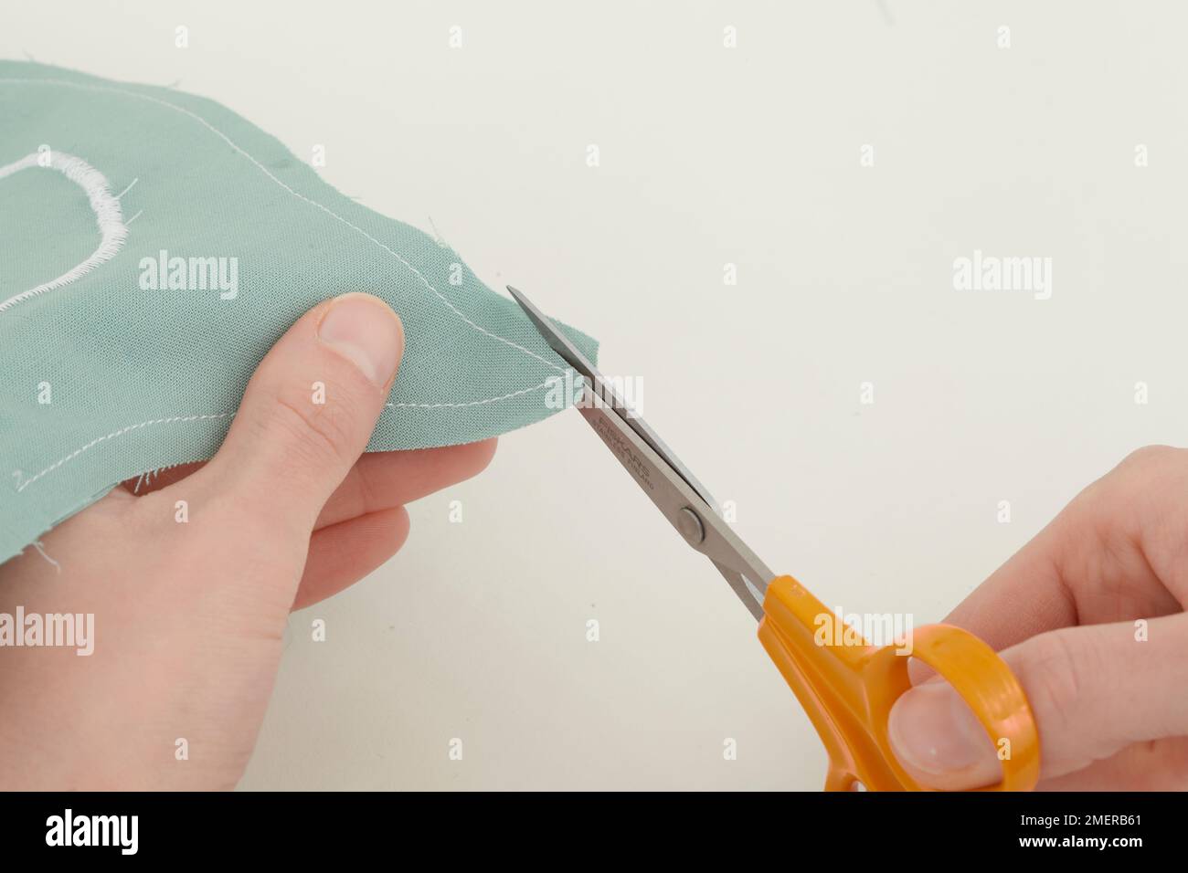 Trim the seam allowance, making cushion Stock Photo Alamy
