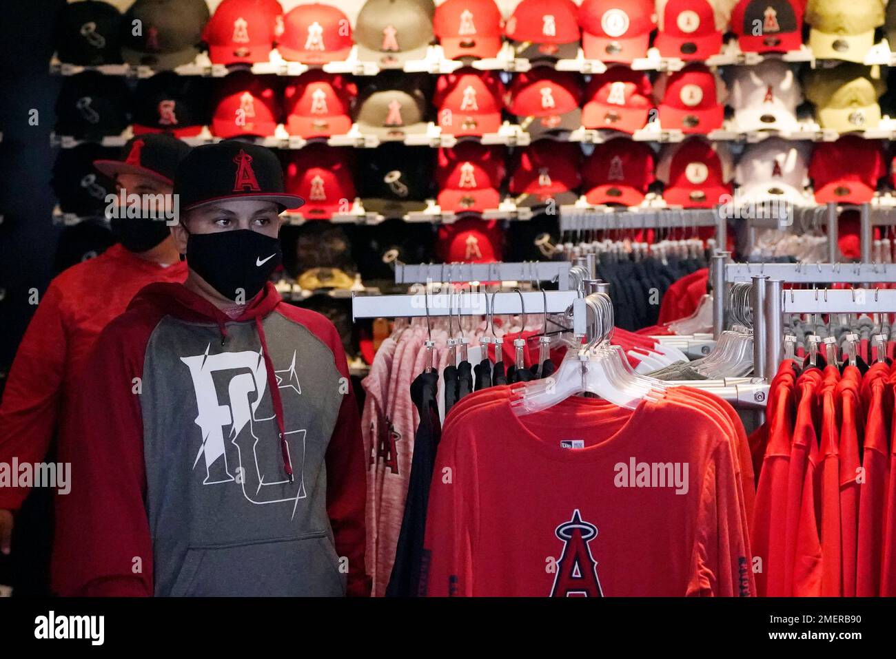 Fans wear masks while walking in the gift shop before a baseball game  between the Los Angeles Angels and the Houston Astros Monday, April 5,  2021, in Anaheim, Calif. (AP Photo/Marcio Jose