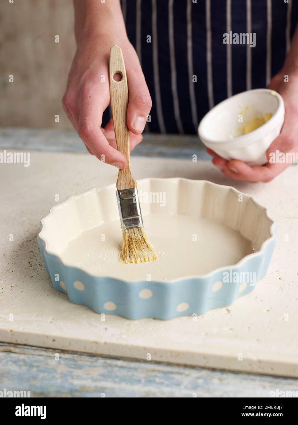 Corn bread, buttering large round baking dish Stock Photo - Alamy