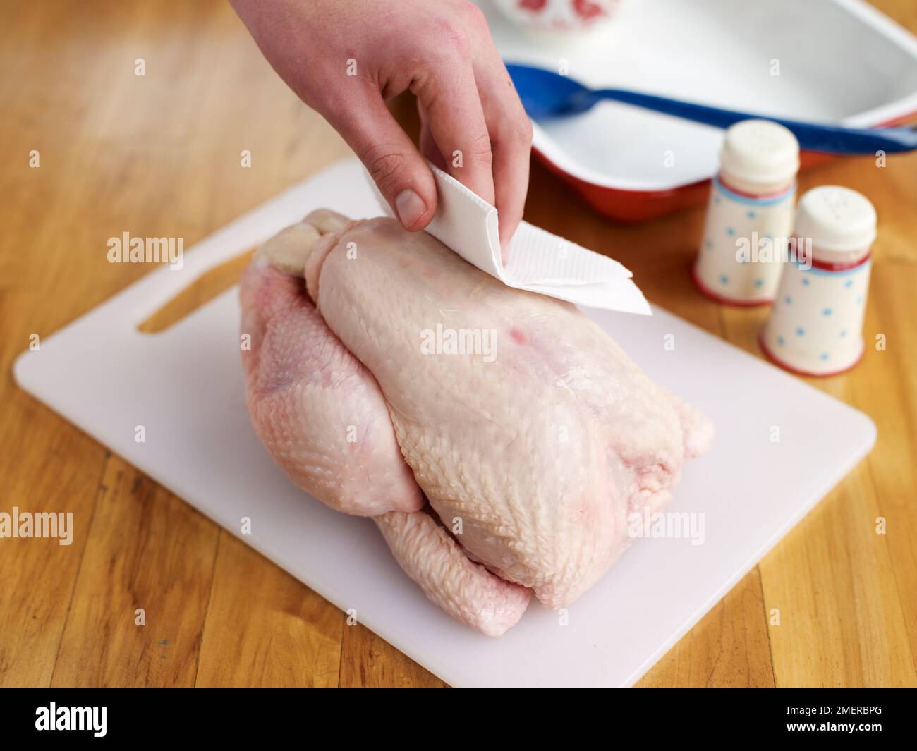 Roast chicken, drying skin of whole raw chicken with kitchen paper