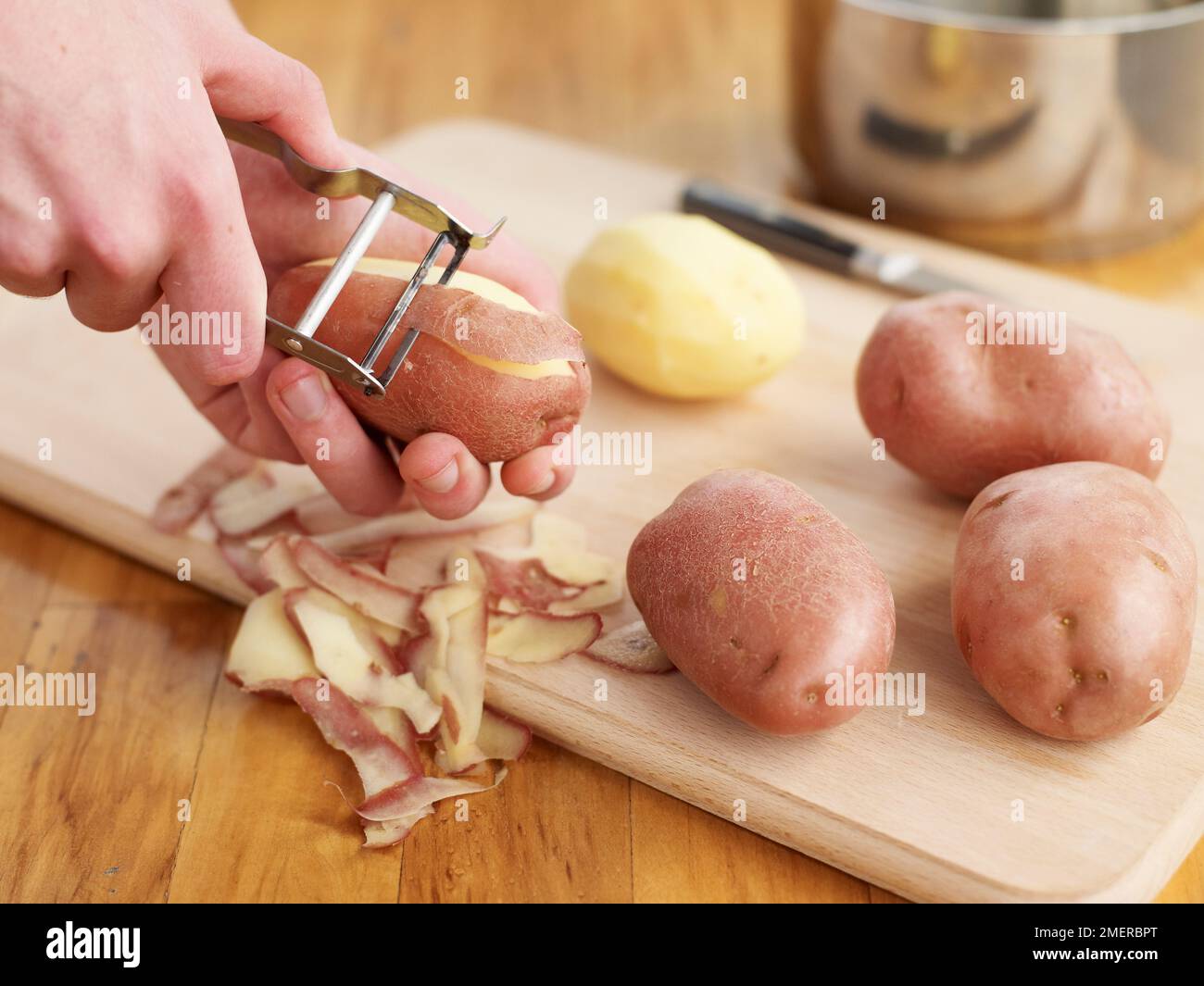https://c8.alamy.com/comp/2MERBPT/peeling-potatoes-with-potato-peeler-2MERBPT.jpg