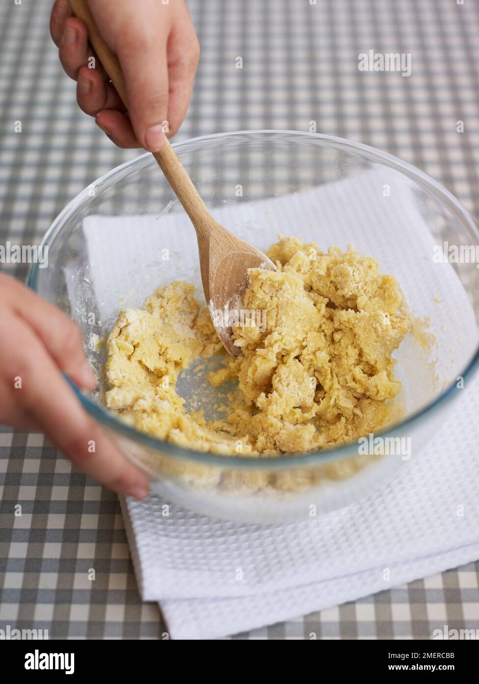 Making basic cookie or biscuit dough, mixing in flour with spoon Stock Photo