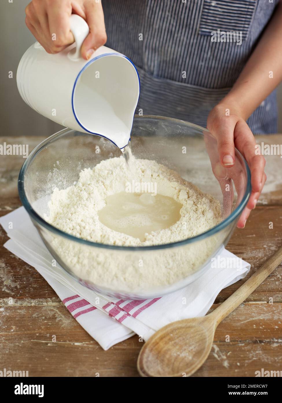Pouring water into a bowl of flour Stock Photo Alamy