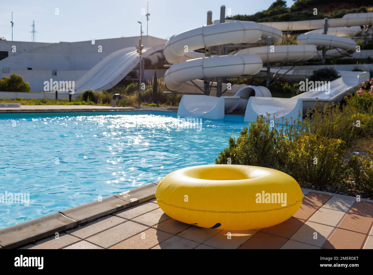 A yellow huge inflatable circle lies at the edge of a large pool with ...