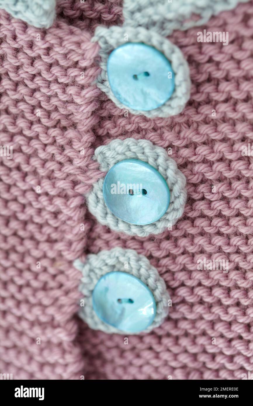 Close up of three button detail of knitted matinee jacket Stock Photo