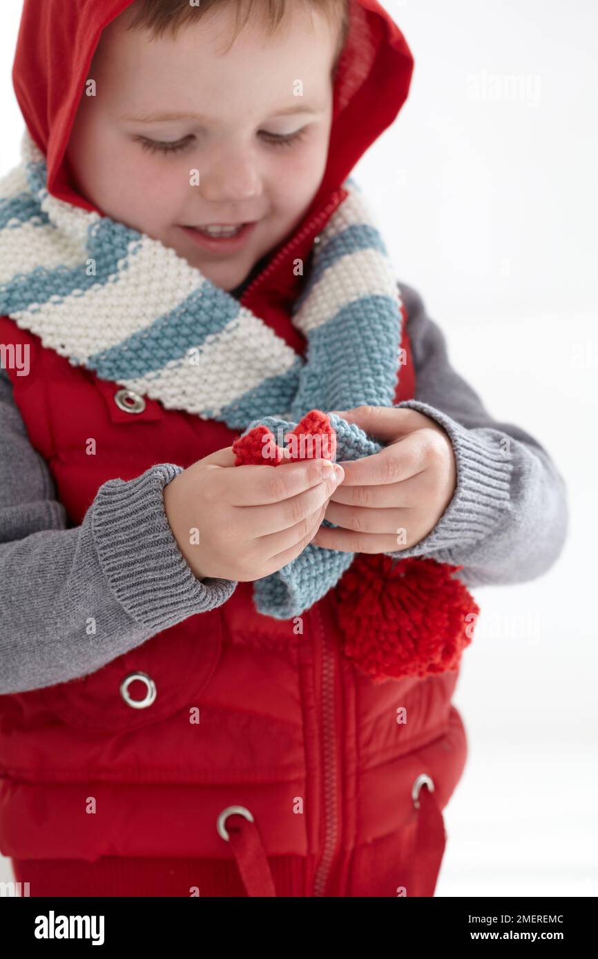 Boy wearing gilet with hood up and wooly scarf, 2 years old Stock Photo