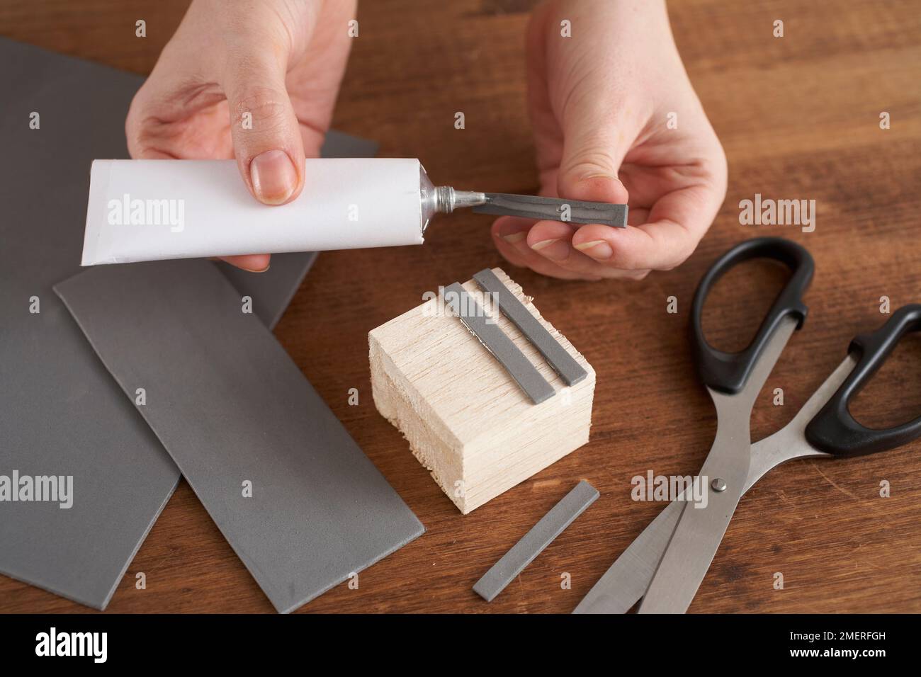 Stamp, gluing cut strips of foam board to wooden block Stock Photo Alamy