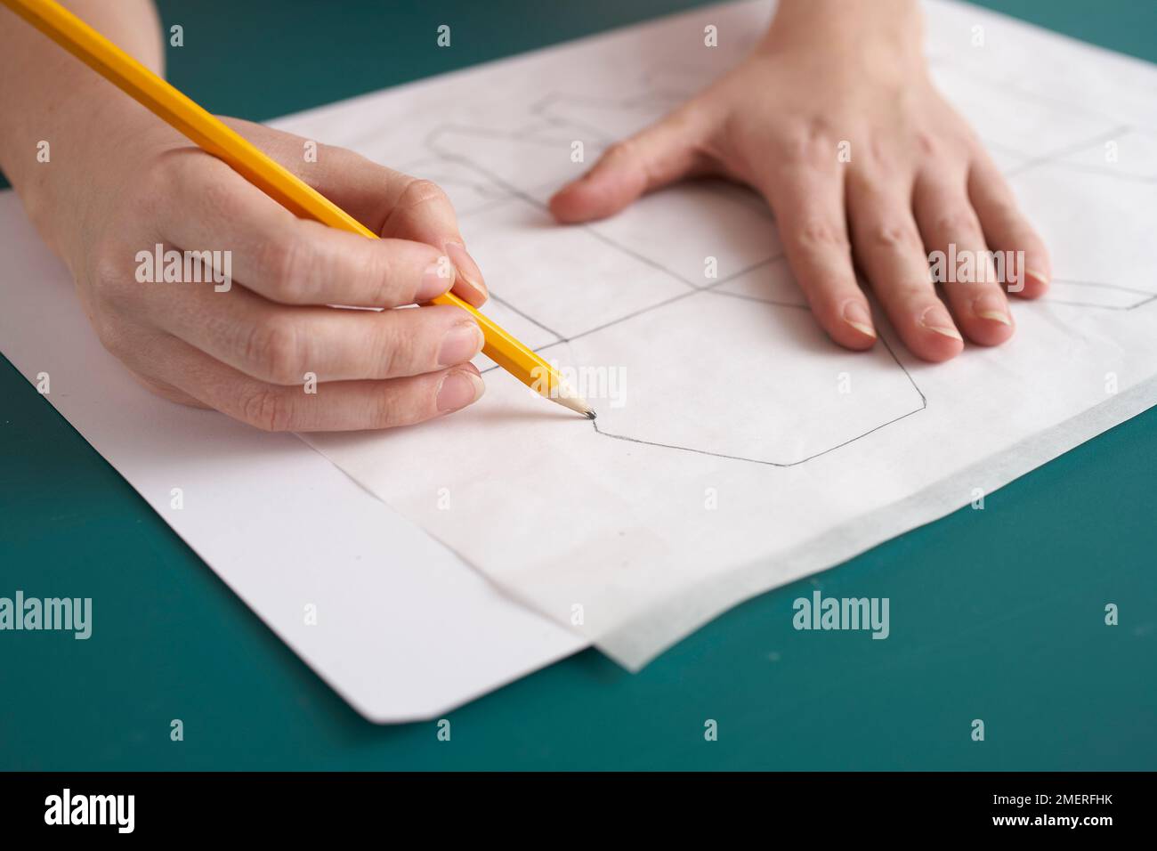 Using tracing paper and a pencil to transfer gift box pattern onto a