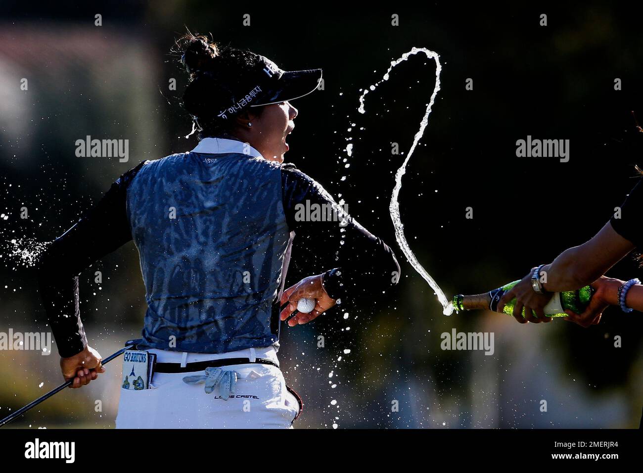 Patty Tavatanakit, of Thailand, is sprayed with bottles of champagne