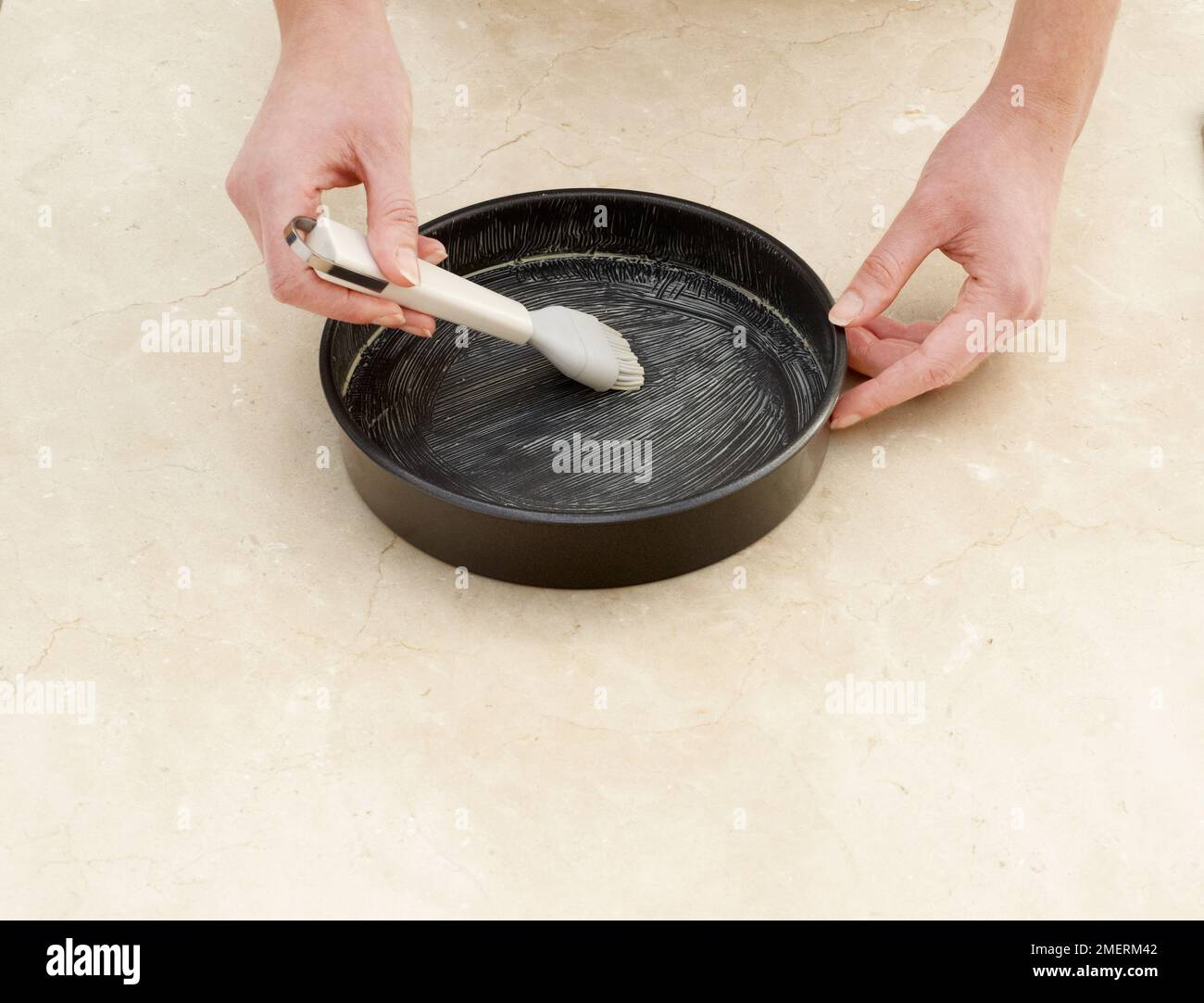 Greasing a cake tin Stock Photo