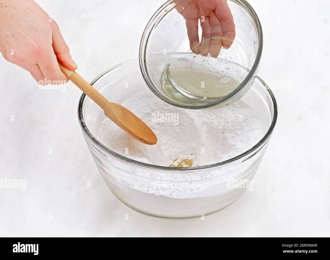 Mixing fondant icing, adding egg white to icing sugar Stock Photo Alamy