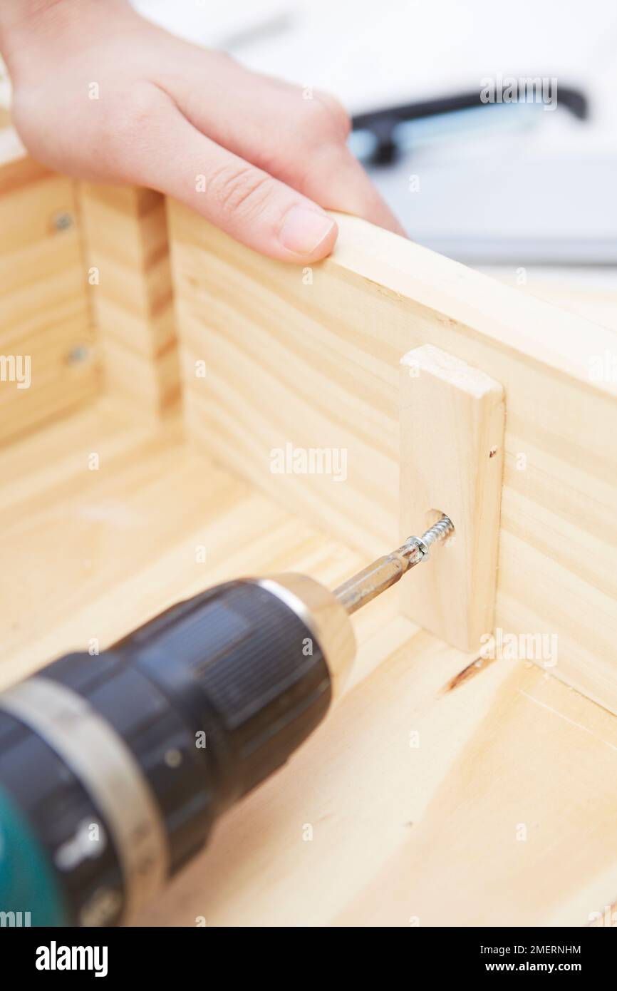 Wallmounted miniature greenhouse made from wooden crates, fixing