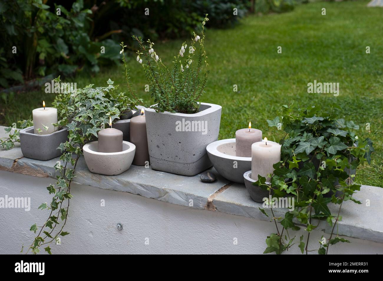 Concrete pots containing plants and candles Stock Photo