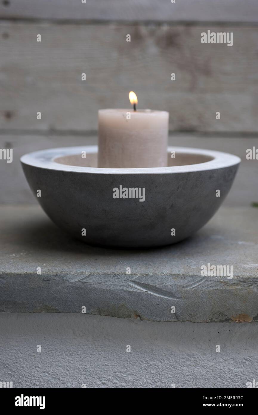 Candle in concrete bowl Stock Photo