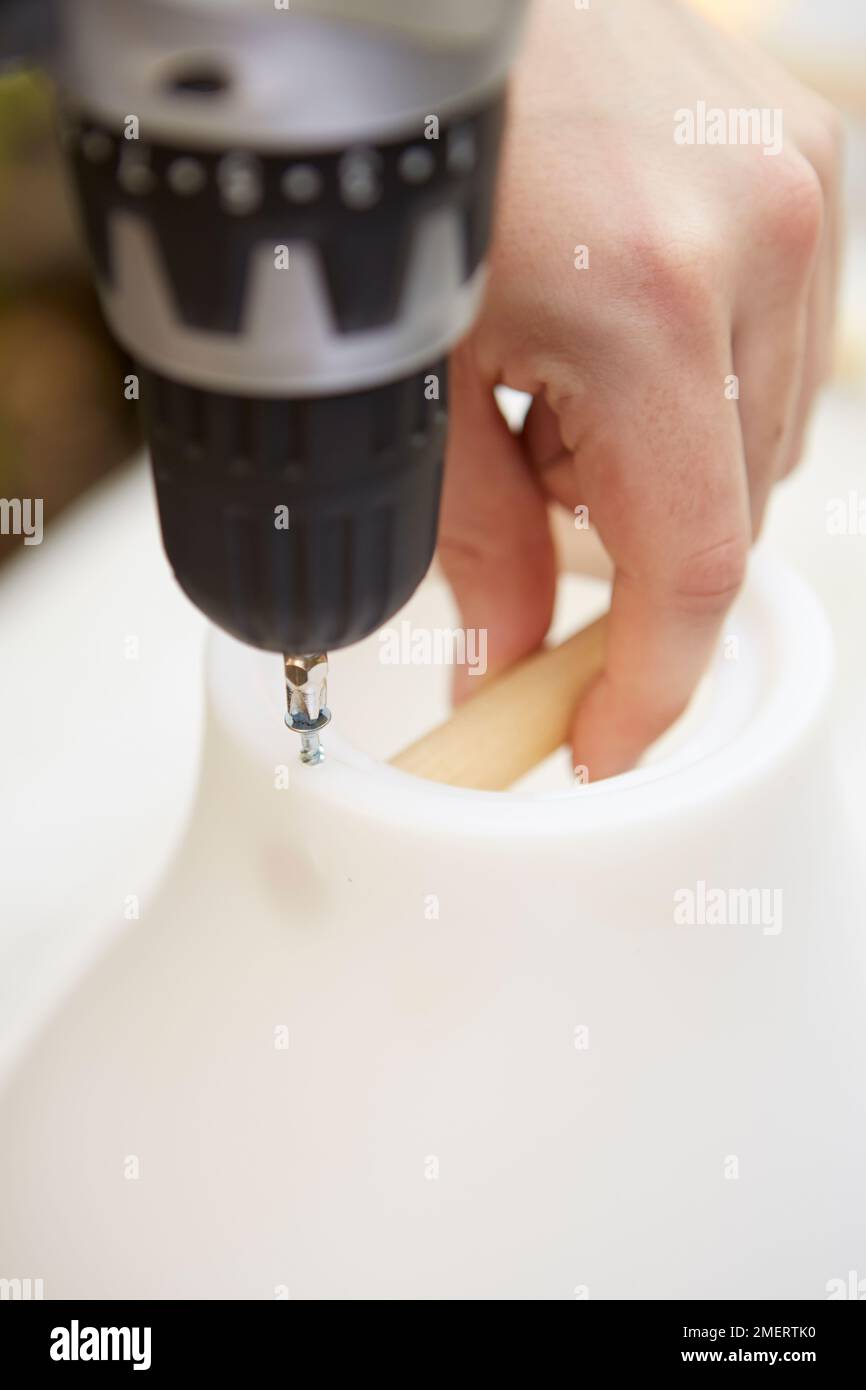 Securing dowel to lampshade for upside down hanging planter Stock Photo