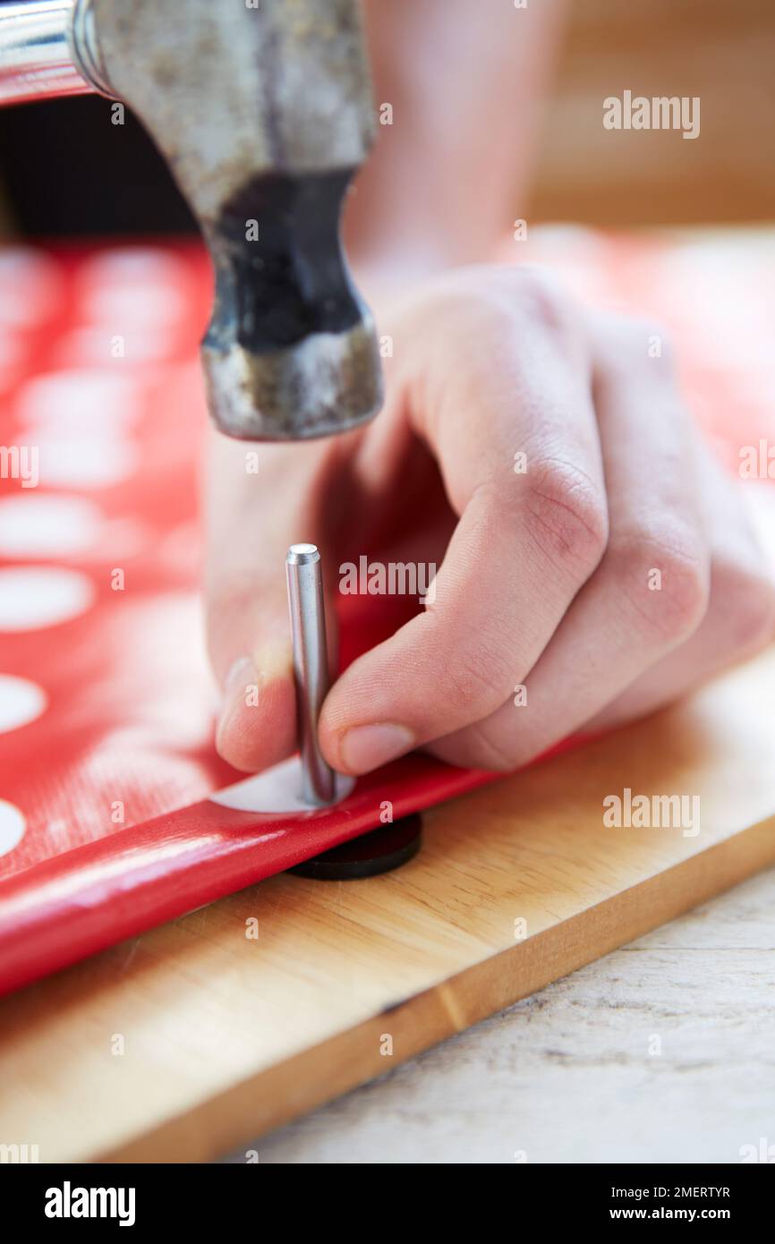 Pinning oilcloth with rivet to make a saddle bag planter Stock Photo