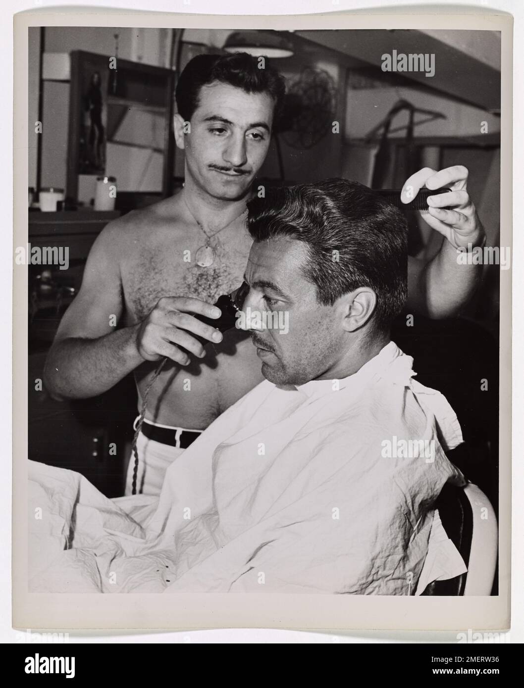 A photograph capturing actor Cesar Romero alongside a barber, offering ...