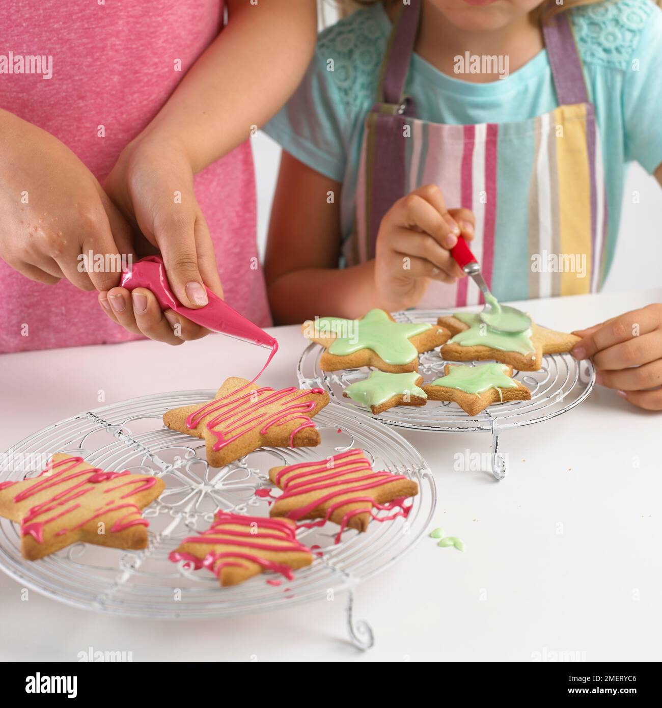 Girl decorating star shaped cookies with icing Stock Photo