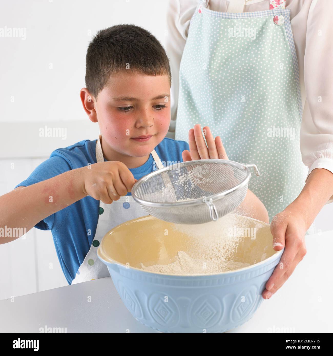 Sieving flour into a mixing bowl, 7 years Stock Photo Alamy
