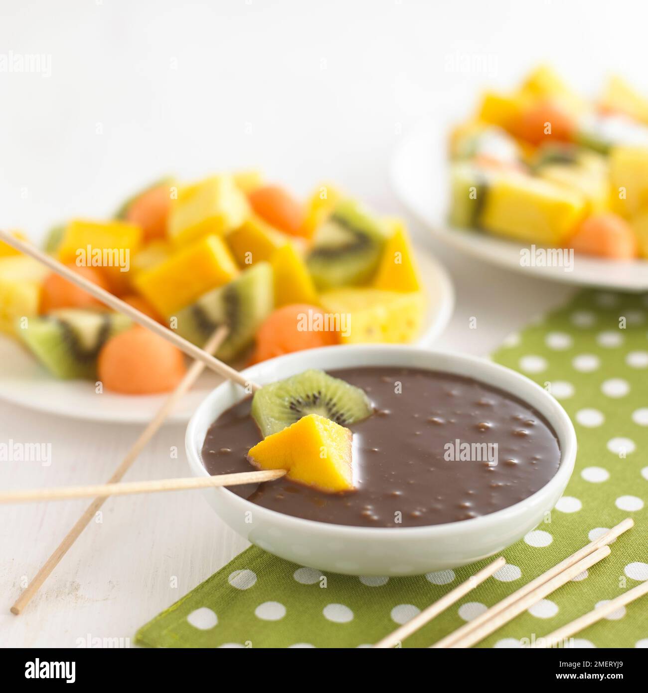 Dipping fruit into chocolate sauce Stock Photo Alamy