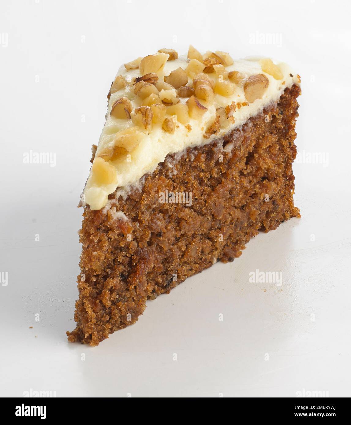 Slice of walnut cake topped with cream icing and chopped nuts Stock