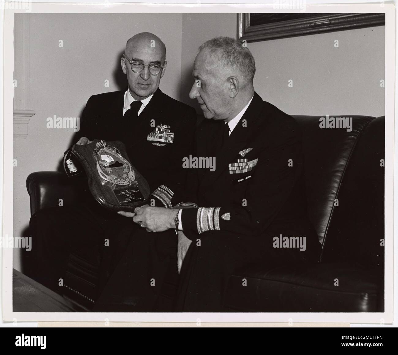 Rear Admiral Lawrence R. Daspit, U.S. Navy, presents a plaque to Rear Admiral F. A. Leamy, superintendent of the U.S. Coast Guard Academy. Rear Admiral Lawrence R. Daspit, USN, (left), commander, Submarine Force, Atlantic Fleet, presents a plaque to Rear Admiral F.A. Leamy, USCG, superintendent of the U.S. Coast Guard Academy. The plaque, which displays the emblem of the North Atlantic Submarine Fleet, was given to Admiral Leamy 'in appreciation of his loyal friendship to the Submarine Force, United States Atlantic Fleet.'. Stock Photo