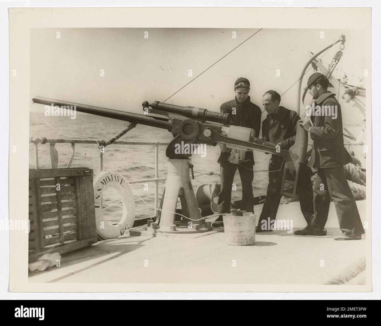 Gunnery. This image depicts Coast Guardsmen firing the Camden line - throwing a projectile from the 6-pounder. This line and gun are used in extremely bad weather, where the shoulder line-throwing gun is inadequate. Stock Photo