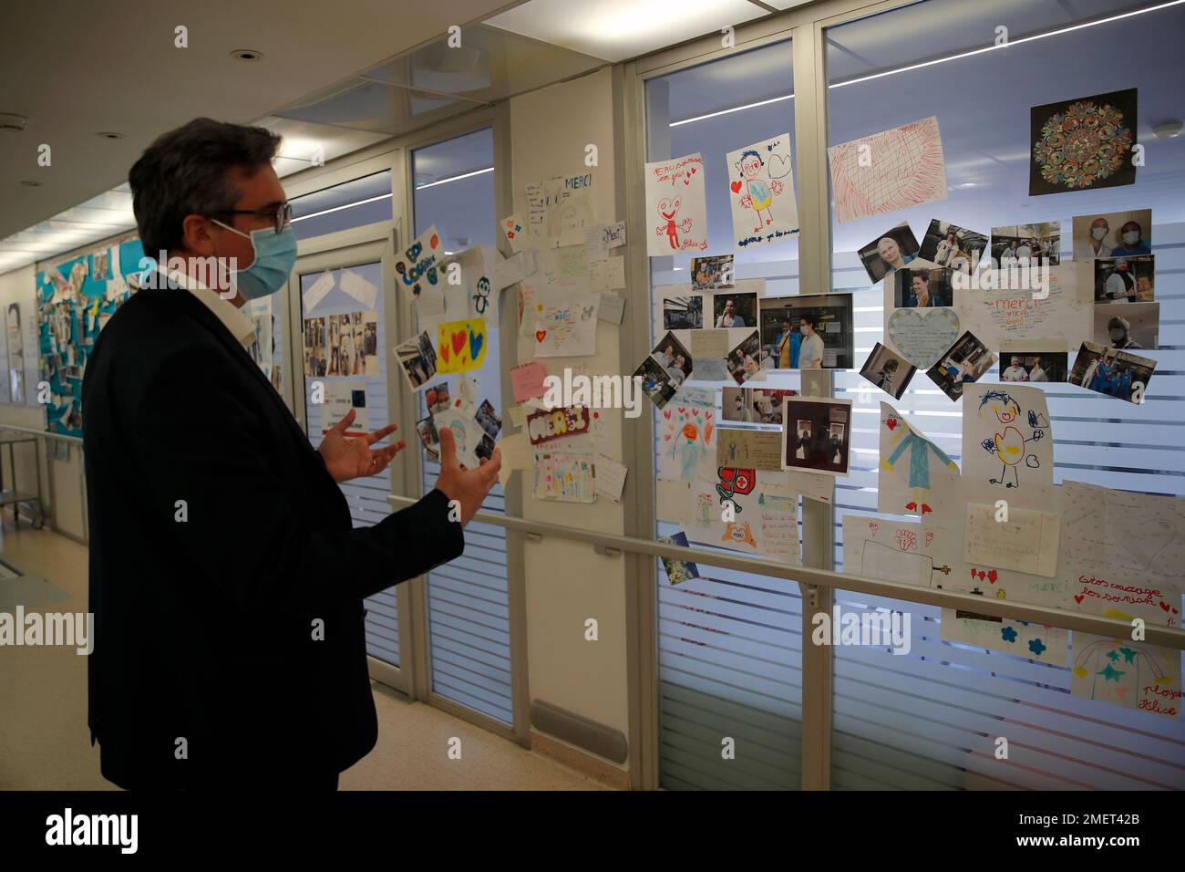 Thomas Lauret, general director of the Porte Verte Hospital shows the wall  decorated with paintings and pictures of gratitude in Versailles, west of  Paris, Friday, April 2, 2021. As French hospitals fill