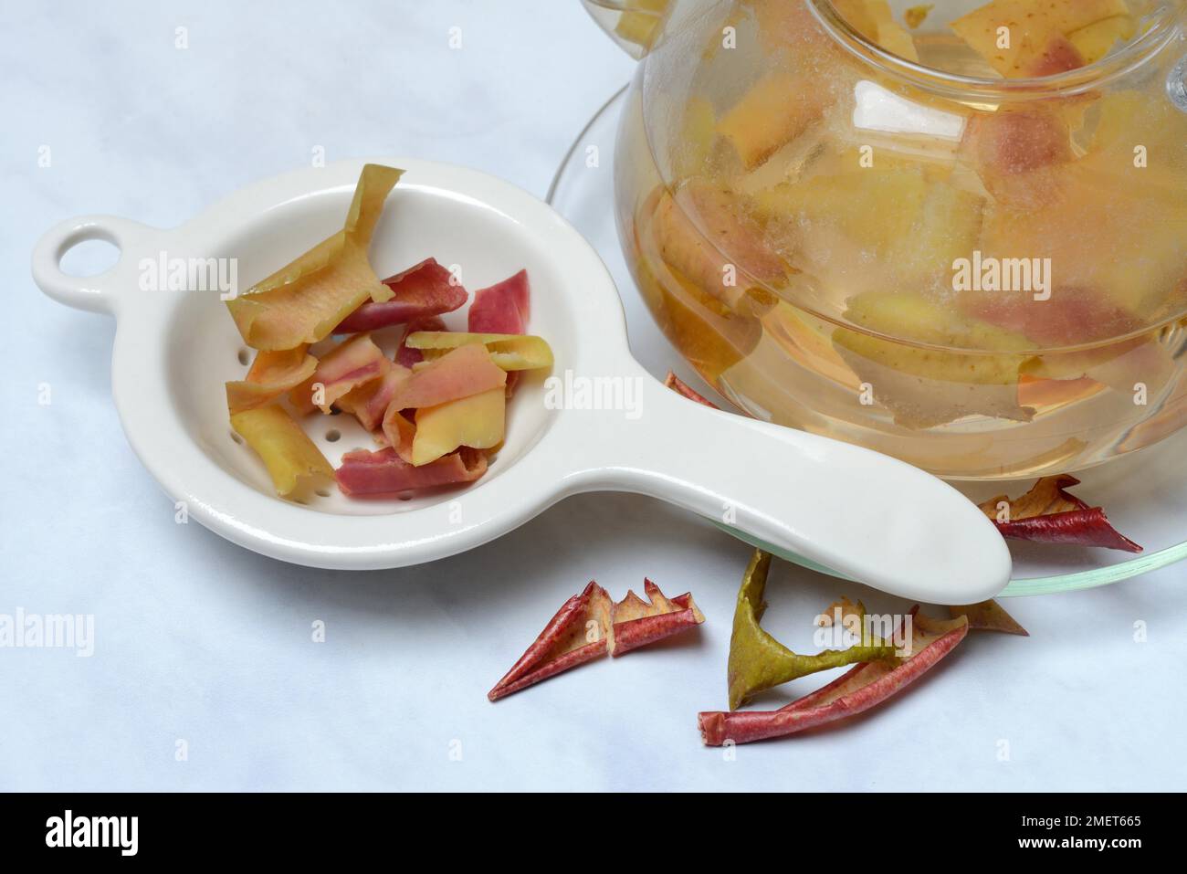 Apple peel tea in teapot and apple peel in tea strainer, apple Stock