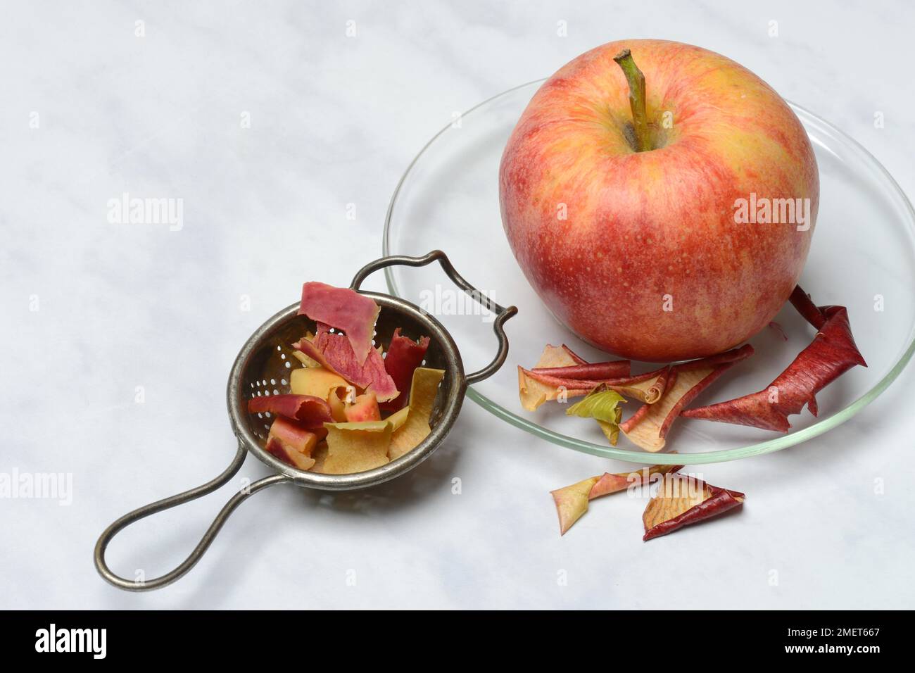 Apple peel tea in tea strainer and apple, tea Stock Photo Alamy