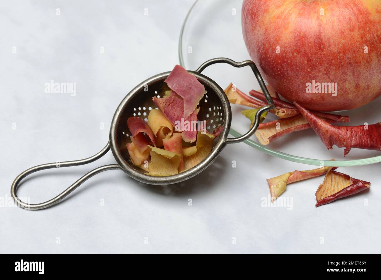 Apple peel tea in tea strainer and apple, tea Stock Photo Alamy