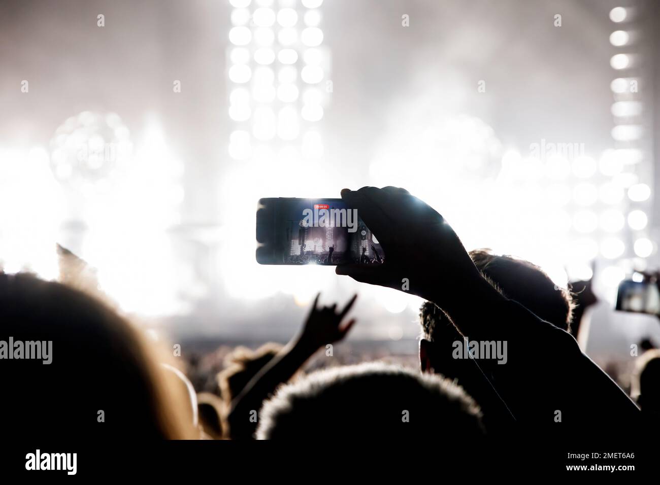 Hand with a smartphone record live music festival and taking photos of